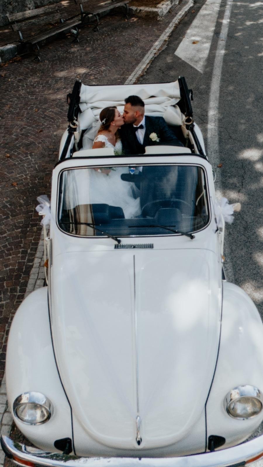 Bacio degli sposi nel Maggiolino con tetto aperto