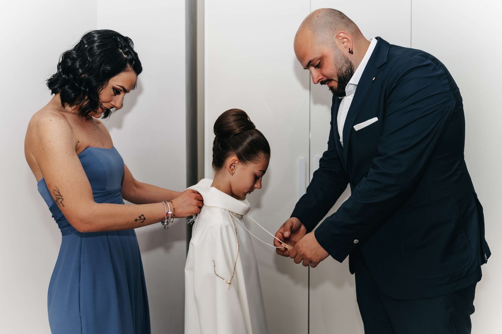 Genitori durante la vestizione, la collana